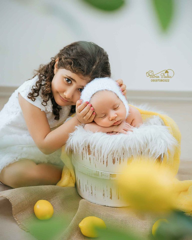 عکاس حرفه‌ای در حال عکاسی از نوزاد
